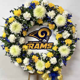 Floral wreath with white, yellow, and blue flowers around a Los Angeles Rams logo
