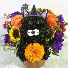 Cat-shaped floral arrangement in a pumpkin container with orange roses and sunflowers