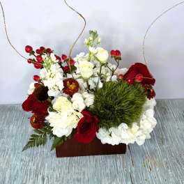 Red and white floral arrangement in a wooden box with curly gold accents