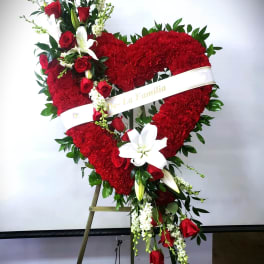 Heart-shaped red floral standing tribute with roses and lilies