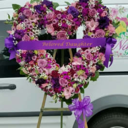 Heart-shaped floral wreath with a purple ribbon reading Beloved Daughter