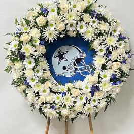 White floral wreath around a Dallas Cowboys helmet display