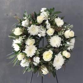 White rose and chrysanthemum wreath on a black stand