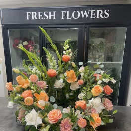 Large floral arrangement with peach, white, and pink blooms