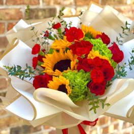 Bouquet of red roses, sunflowers, and green hydrangeas wrapped in cream paper
