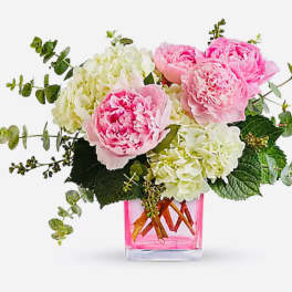 Pink peonies and white hydrangeas in a pink glass vase