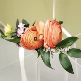 Orange and peach floral wrist corsage with white ribbon