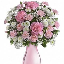 Pink and white flower arrangement in a pink glass vase