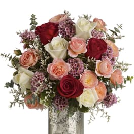 Bouquet of red, white, and peach roses in a silver vase