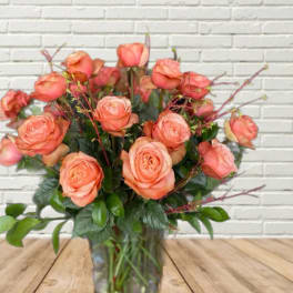 Peach roses arranged in a clear glass vase