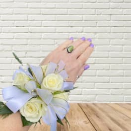 White rose wrist corsage with lavender ribbon and gold trim