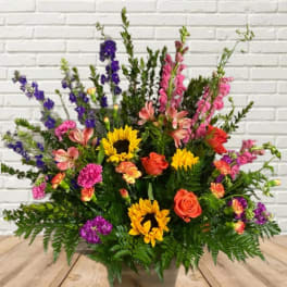 Large mixed flower arrangement with sunflowers, roses, and pink and purple blooms