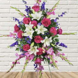Standing floral spray with pink roses, white lilies, and purple accents