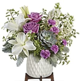 White lilies and purple roses in a white vase