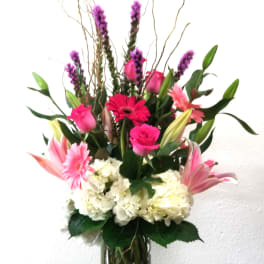 Tall mixed bouquet in a clear glass vase with pink and white flowers