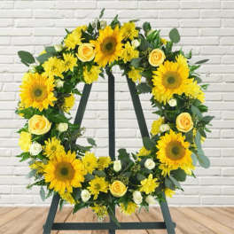 Yellow floral wreath on a black easel stand