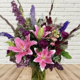 Bouquet of pink lilies and purple flowers in a hand-tied arrangement