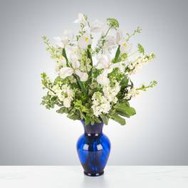 White iris arrangement in a blue glass vase