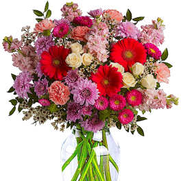 Mixed pink and red flowers in a clear glass vase