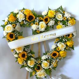 Heart-shaped floral wreath with yellow and white roses and sunflowers