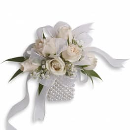 White rose wrist corsage with sheer ribbon bows and a pearl bracelet band