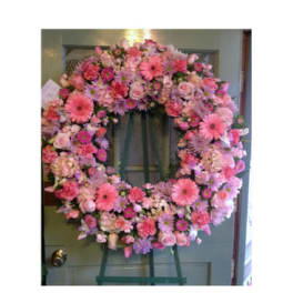 Pink floral wreath on a green easel stand
