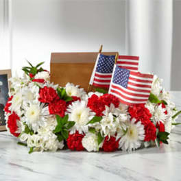 Red and white floral arrangement with small American flags