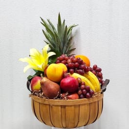 Fruit basket with grapes, bananas, pears, apples, and a yellow lily