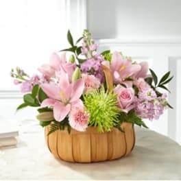 Pink lilies and roses in a pumpkin-shaped basket