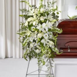 White floral standing spray beside a casket
