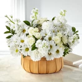 White daisies and roses arranged in a pumpkin-shaped basket