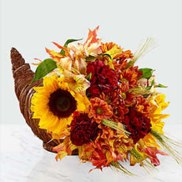 Cornucopia filled with sunflowers and autumn flowers