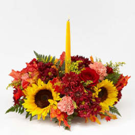 Autumn floral centerpiece with a yellow taper candle