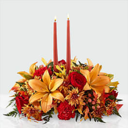 Autumn floral centerpiece with two red taper candles