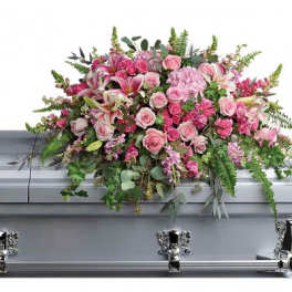 Pink rose and lily casket spray arranged on a silver casket