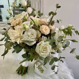 White and blush rose bouquet with eucalyptus in a white vase
