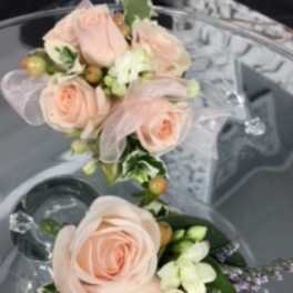 Wedding corsage of blush roses with white accents and ribbon in a compact double cluster design