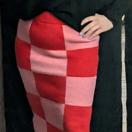 Person holding a red and pink checkered fabric item