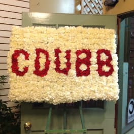 Large floral sign with red letters on a cream flower background