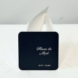 Black gift card with white text in a white paper holder