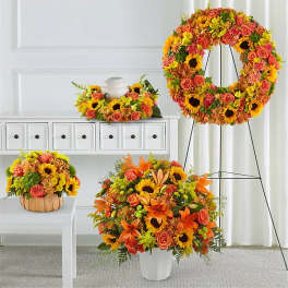 Bright floral wreath and arrangements with sunflowers and orange roses