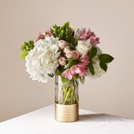 Pink and white flower arrangement in a clear glass vase