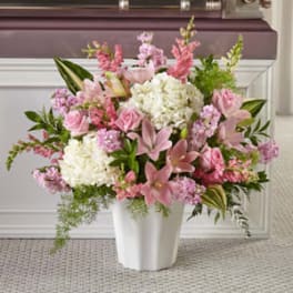 Pink and white floral arrangement in a white vase