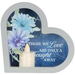 Heart-shaped memorial plaque with blue flowers and a candle