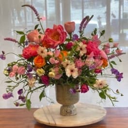Colorful mixed flower arrangement in a pedestal vase