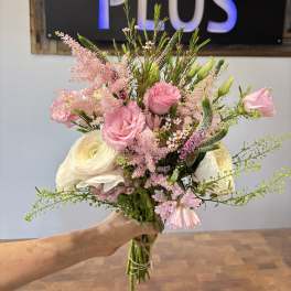 Handheld bouquet of pink and white flowers with airy greenery