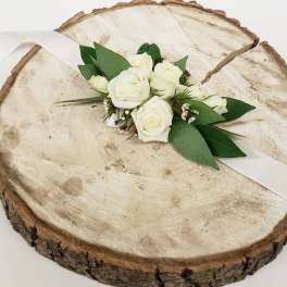 White rose boutonniere on a wood slice with white ribbon