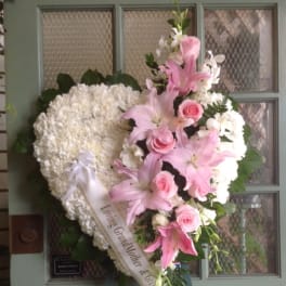 Heart-shaped funeral wreath with pink lilies, roses, and white flowers