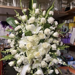 Large white funeral standing spray with roses and lilies