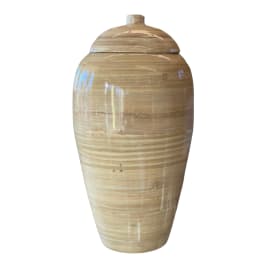 Tall beige ceramic urn with a lid on a white background